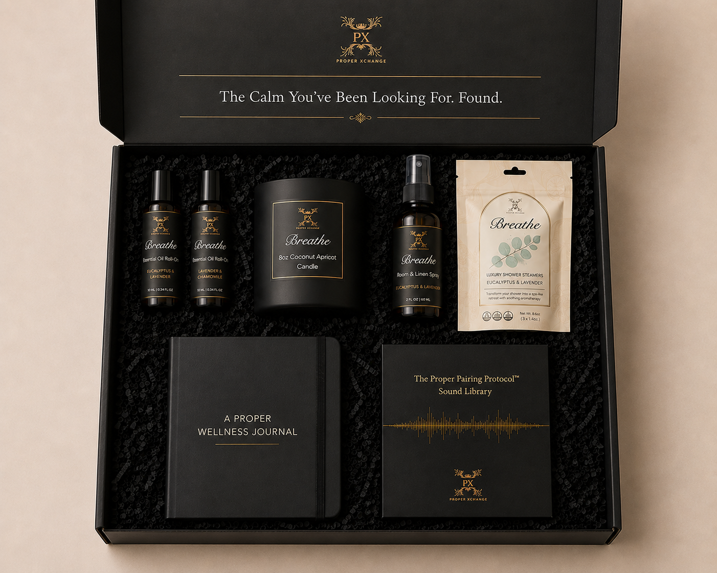 Gifting set with wellness products including candles, oils, and a journal in a black box.