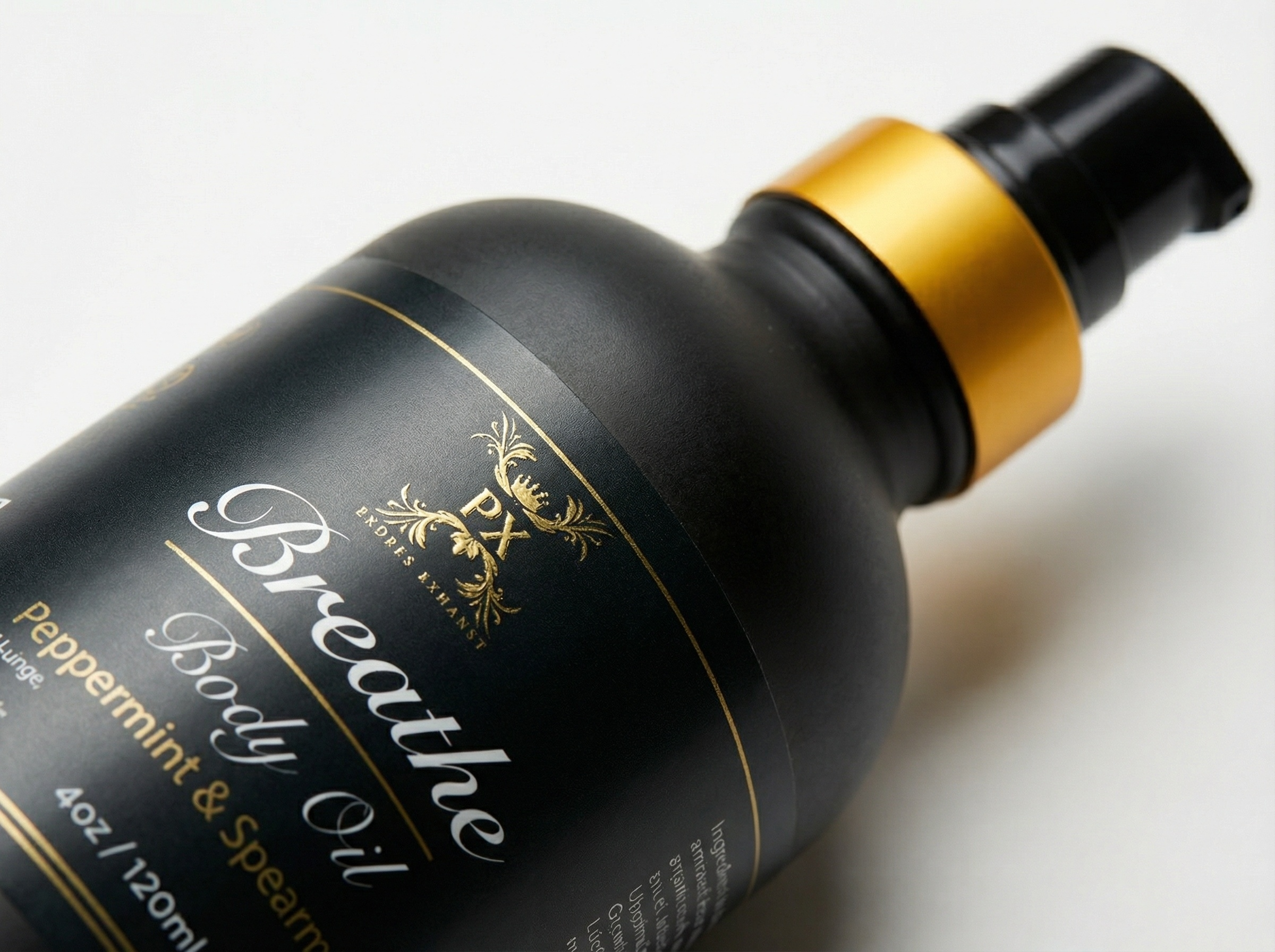 Black bottle of 'Breathe' body oil with gold cap on a white background