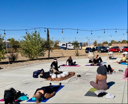 Group of people practicing yoga outdoors on a sunny day.
