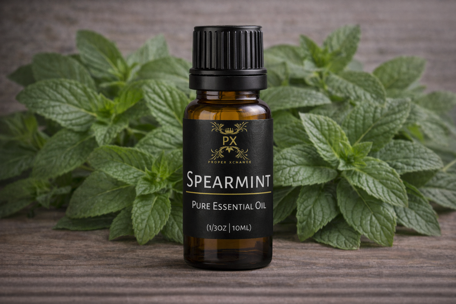 Spearmint pure essential oil bottle with spearmint leaves on a wooden surface