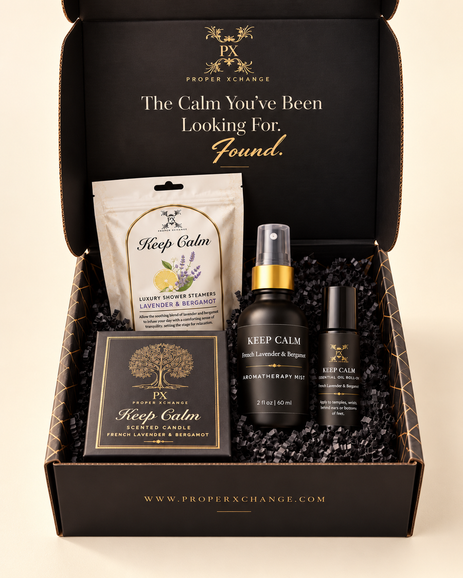 Keep Calm Rituals Gift Set in an open black and gold gift box with candle packaging, shower steamers, 2 oz mist, and roll-on on an ivory background